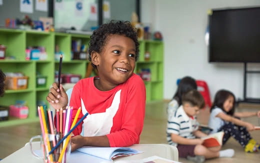 a young girl holding a pencil