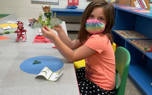 a girl with a paintbrush in her mouth