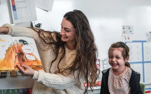 a woman showing a woman something on a paper
