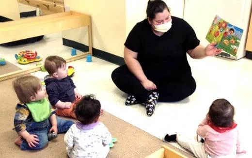 a person reading a book to children