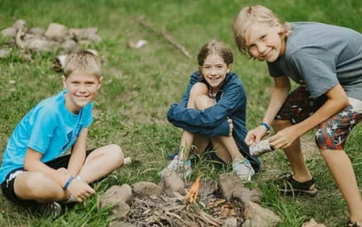 a group of children sitting on the grass