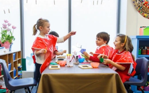 a group of children sitting around a table