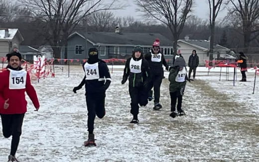 a group of people running in the snow