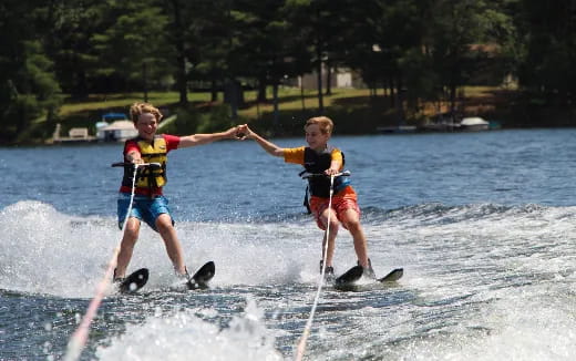 a couple of kids water skiing
