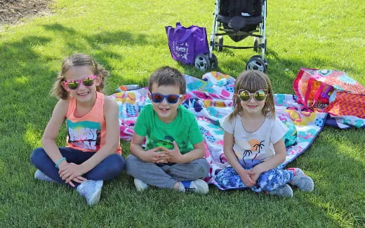a group of children sitting on the grass