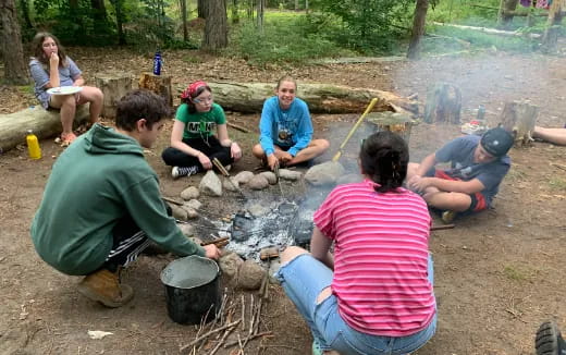 a group of people sitting around a fire pit