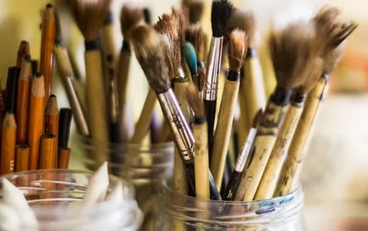 a group of brushes in a glass