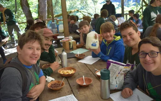 a group of people sitting at a table with food
