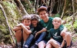 a group of people sitting in the woods