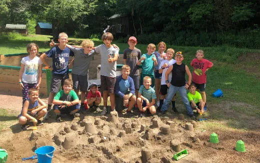 a group of people posing for a photo in the sand