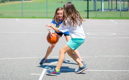 a couple of girls playing basketball