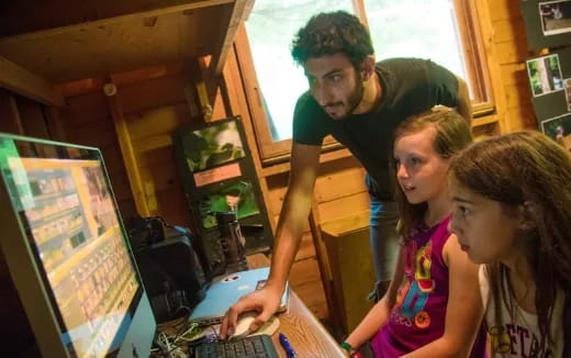 a person showing a girl something on the computer