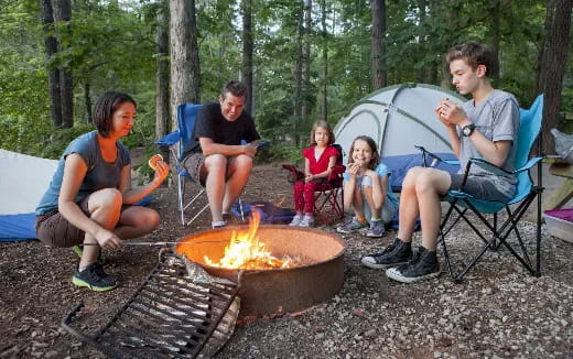 a group of people sitting around a campfire