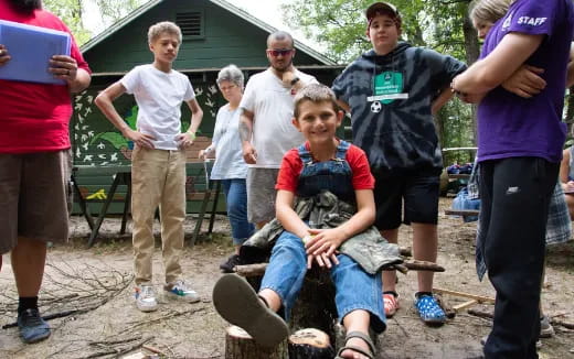 a group of people around a boy sitting on a tire