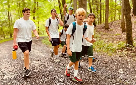 a group of people running on a trail in the woods