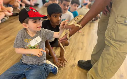 a group of children holding a lizard