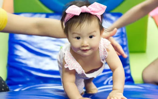 a baby girl wearing a pink bow