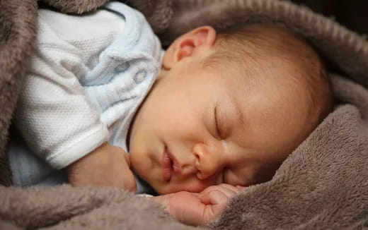 a baby sleeping on a blanket