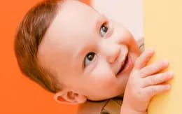 a baby with a hand on its face