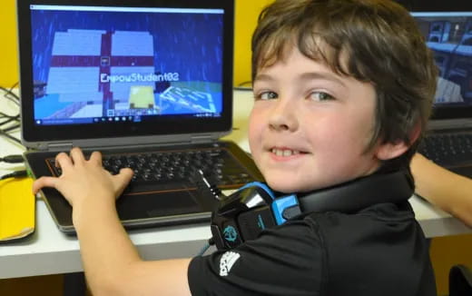 a boy holding a laptop