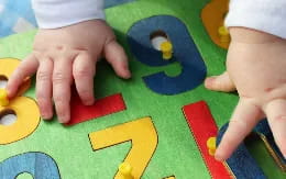 a close-up of a child's hands playing with toys