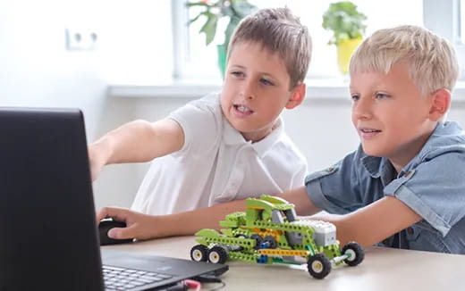 a couple of boys looking at a laptop