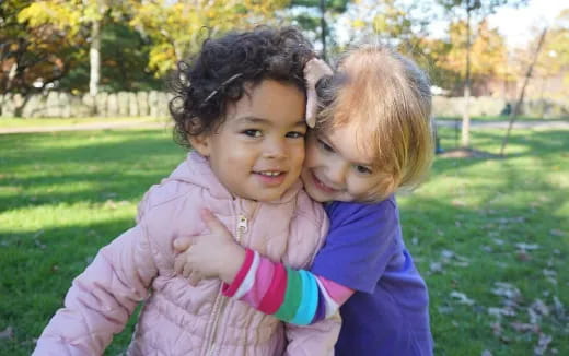 a couple of children hugging in a park
