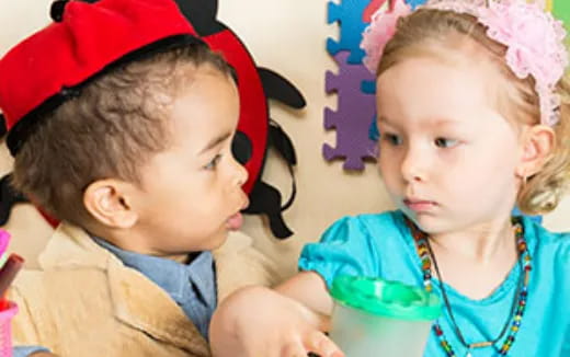 a couple of children wearing red hats