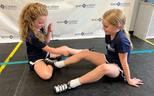 a couple of girls kneeling on the ground