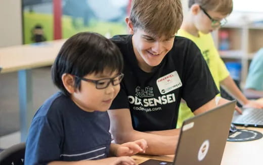 a few young boys using a laptop
