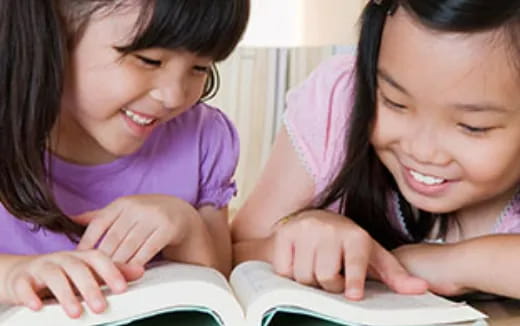 a few young girls looking at a tablet