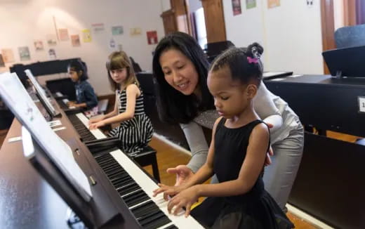 a group of children playing piano