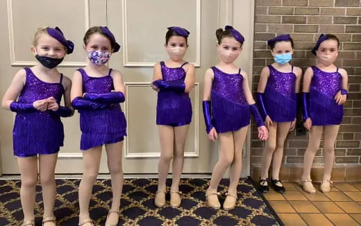 a group of girls in blue dresses