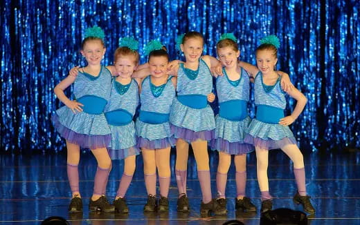 a group of girls in blue dresses