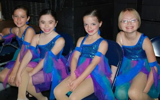 a group of girls in blue dresses
