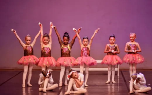 a group of girls in dresses and skirts on a stage