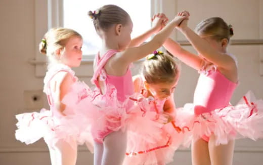 a group of girls in dresses dancing