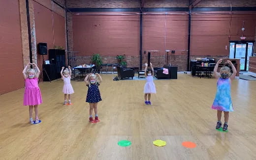 a group of girls in dresses dancing