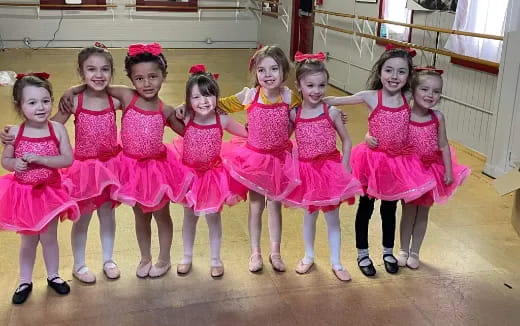 a group of girls in pink dresses