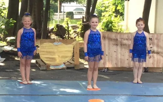 a group of girls standing on a trampoline