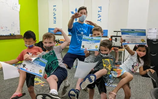 a group of kids holding up boxes