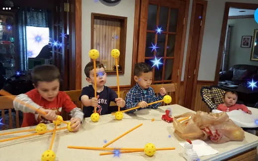 a group of kids sitting at a table with toys