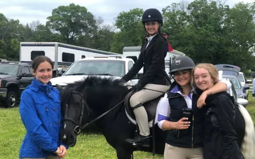 a group of people posing with a horse