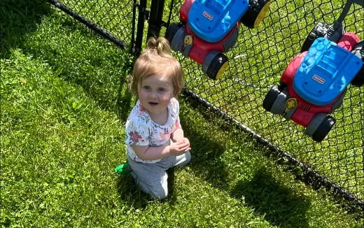 a little girl playing with a toy tractor