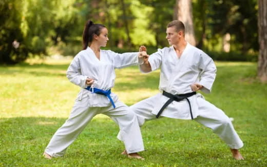 a man and woman in karate uniforms