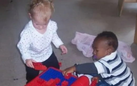a person and a baby playing with a toy