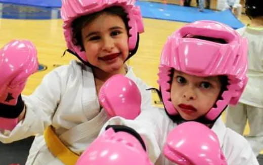 a person and a baby wearing pink helmets