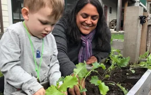 a person and a boy looking at a plant