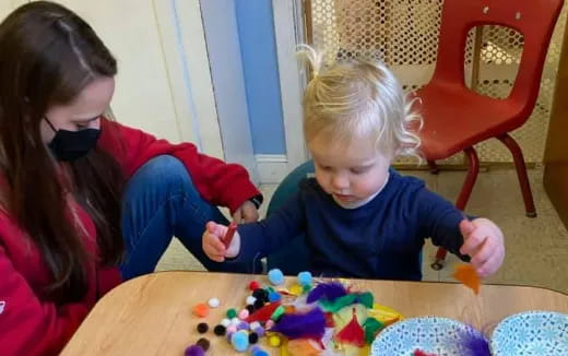 a person and a child playing with toys on a table