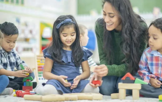 a person and a few children playing with toys